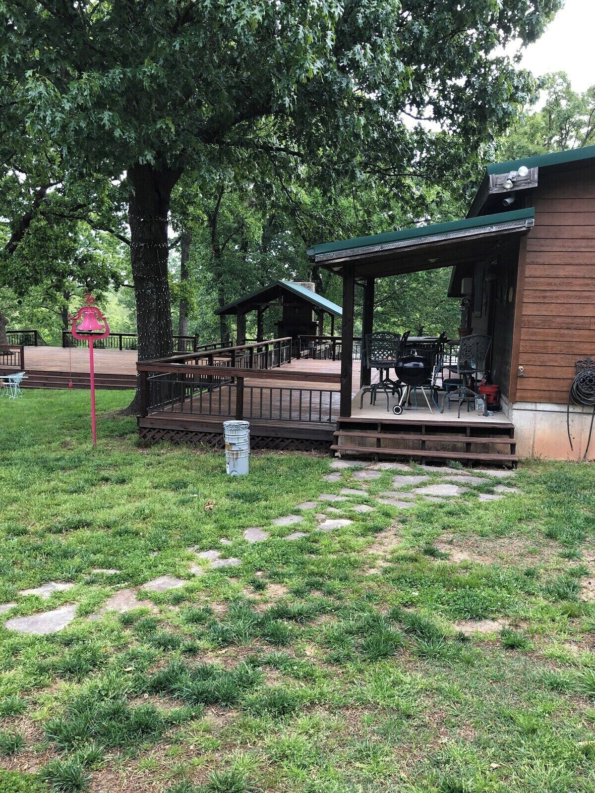Un parque con un pabellón, mesas de picnic y un árbol grande.