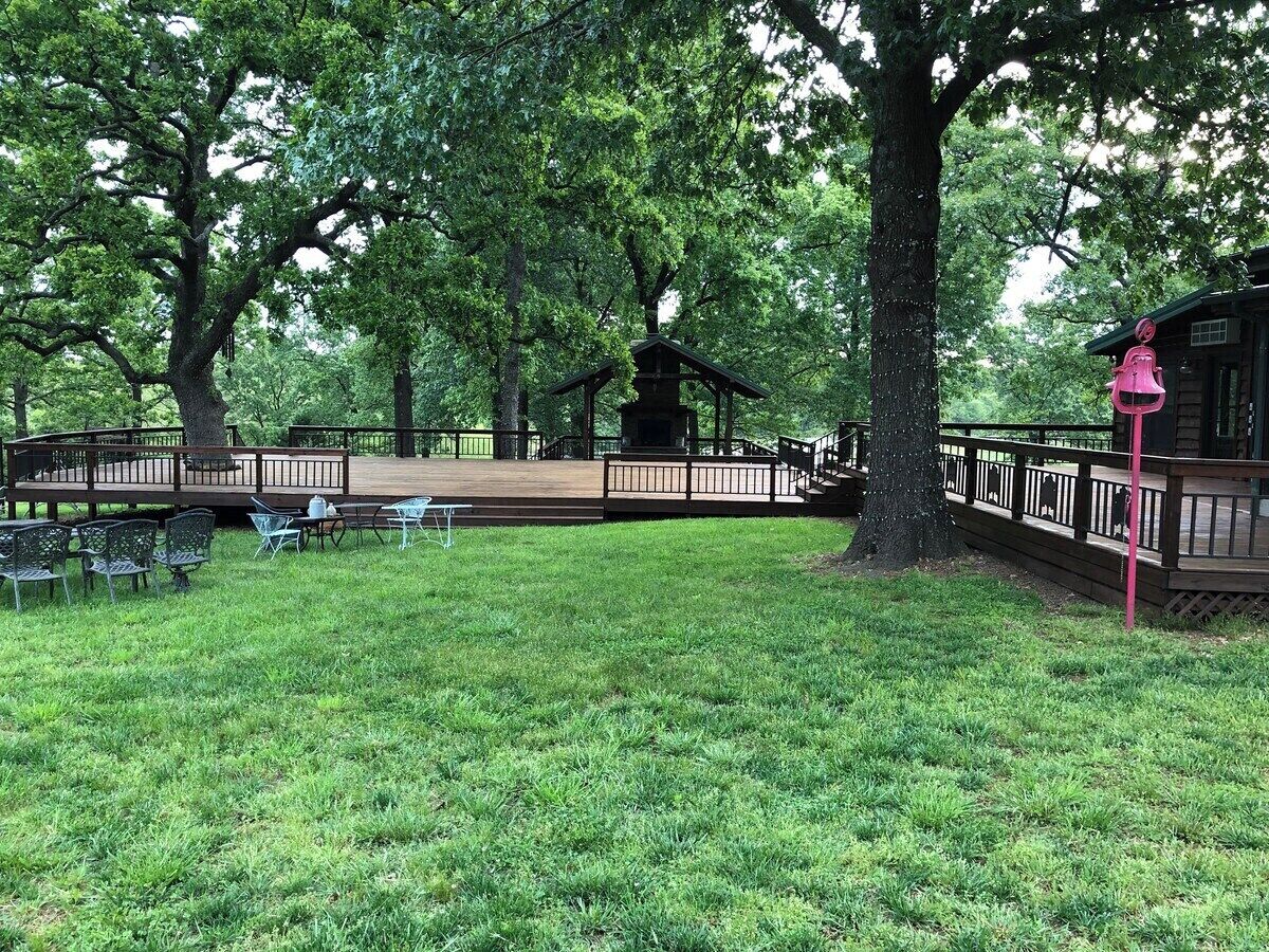 Un parque con un pabellón, mesas de picnic y una terraza de madera.