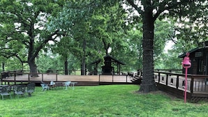 A park with a gazebo, picnic tables, and a wooden deck.