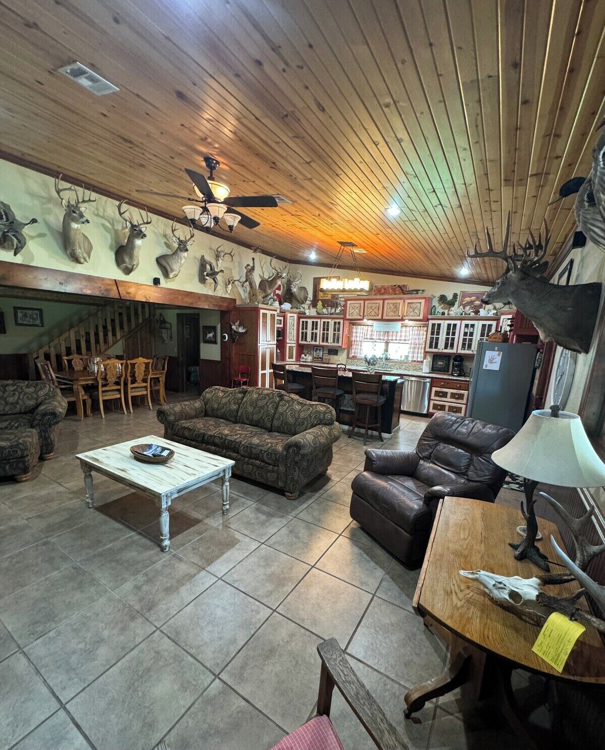 A spacious living room with a fireplace, a dining area, and a kitchen with wooden cabinets.
