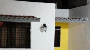 Un área de piscina con suelo de baldosas, una pequeña mesa redonda y dos sillas.