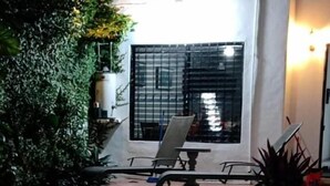 Una piscina con sillones de descanso y una planta en maceta.