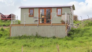 Ein kleines, eingeschossiges Haus mit einer Veranda, einem Fenster und einer Tür.
