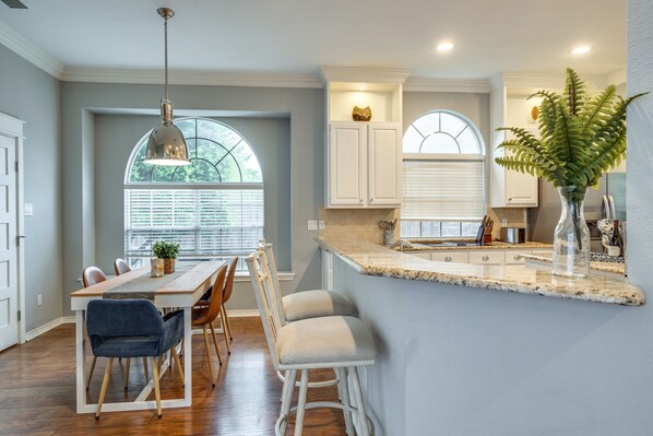 Enjoy cooking in this well-equipped kitchen with a large island, oven, and expansive window offering a view of the outdoors.