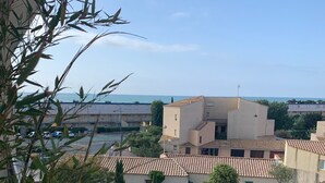 A residential area with buildings, a clear sky, and a view of the sea. - Cosy T3 100m from the beach in a recent residence. (Fleury D'aude)