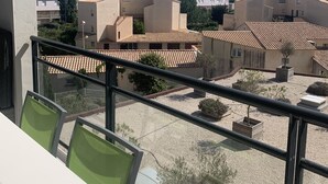 A balcony with a view of a courtyard with buildings and a clear sky. - Cosy T3 100m from the beach in a recent residence. (Fleury D'aude)