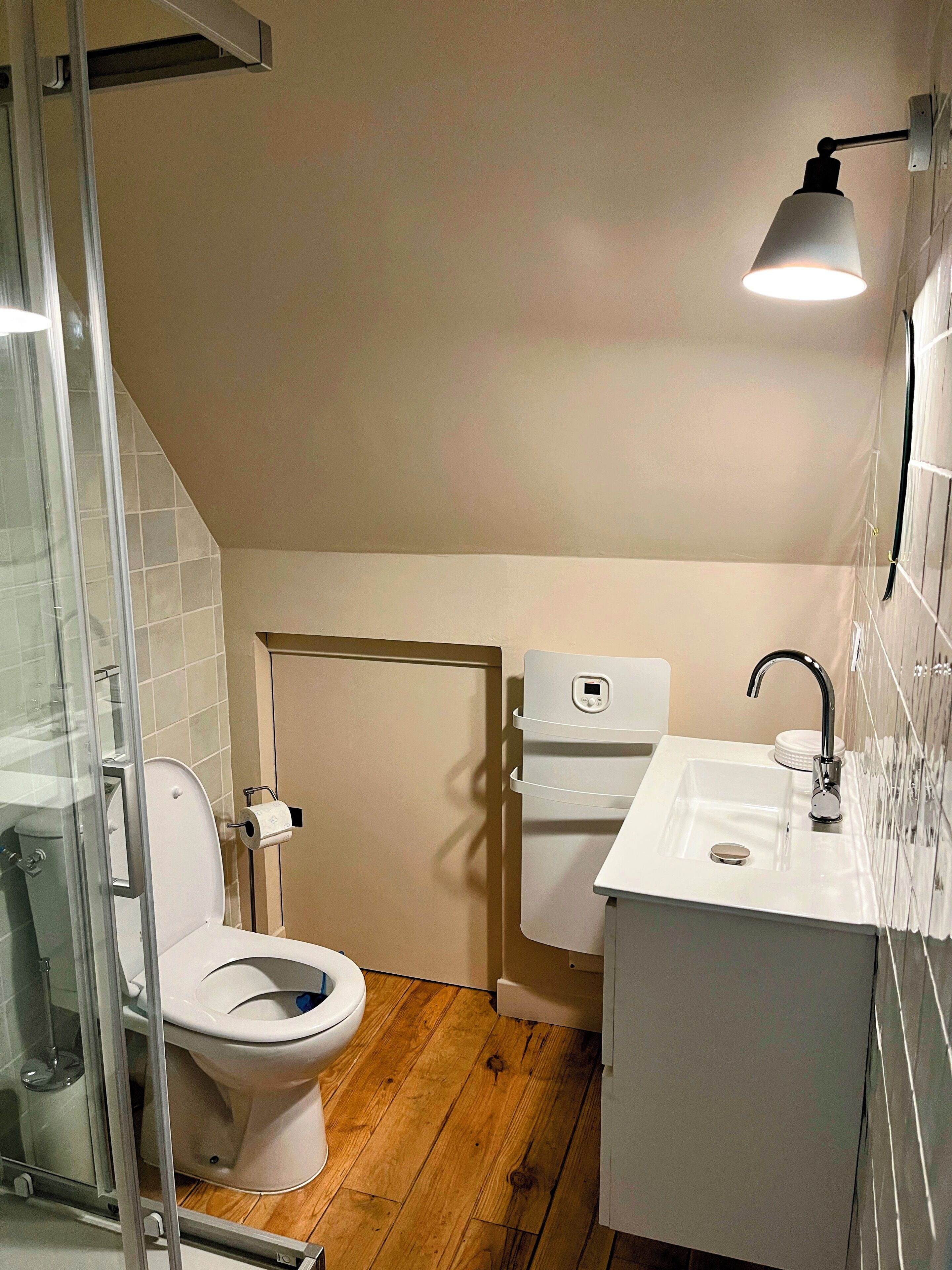 A small, modern bathroom with a toilet, bidet, and sink.
