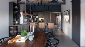 A modern kitchen with dark wood cabinetry, a central island, and pendant lighting.