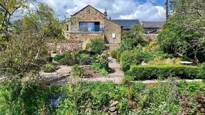 A stone house with a garden in front.
