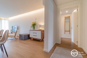 Relax in this stylish living space with a dining area, sofa, and wooden cabinet.