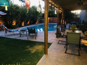 Un espace extérieur aménagé avec une terrasse, une piscine, des chaises longues et des tables.