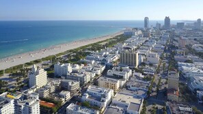 Un paysage urbain côtier avec une plage, des immeubles de grande hauteur et un ciel dégagé.