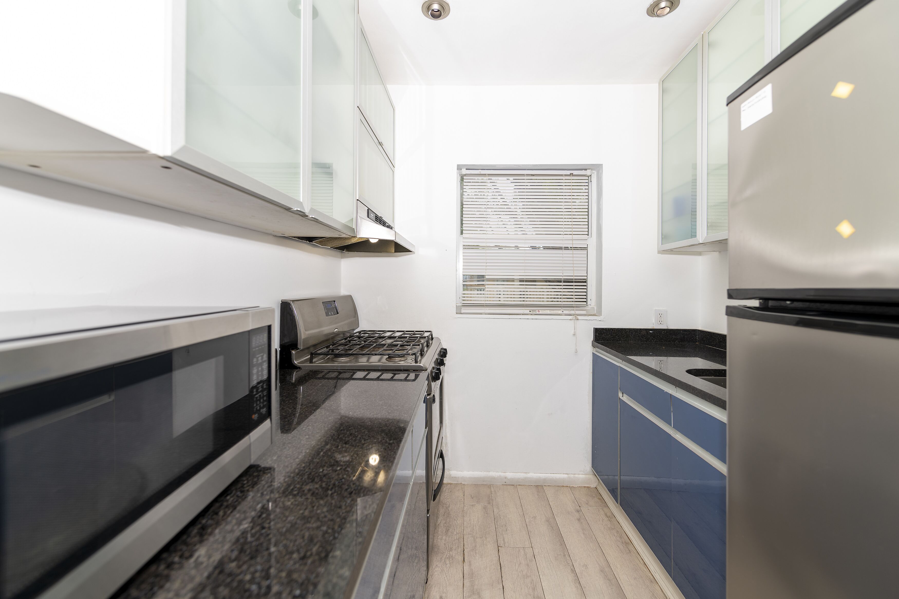 A compact kitchen with a stove, microwave, and refrigerator.