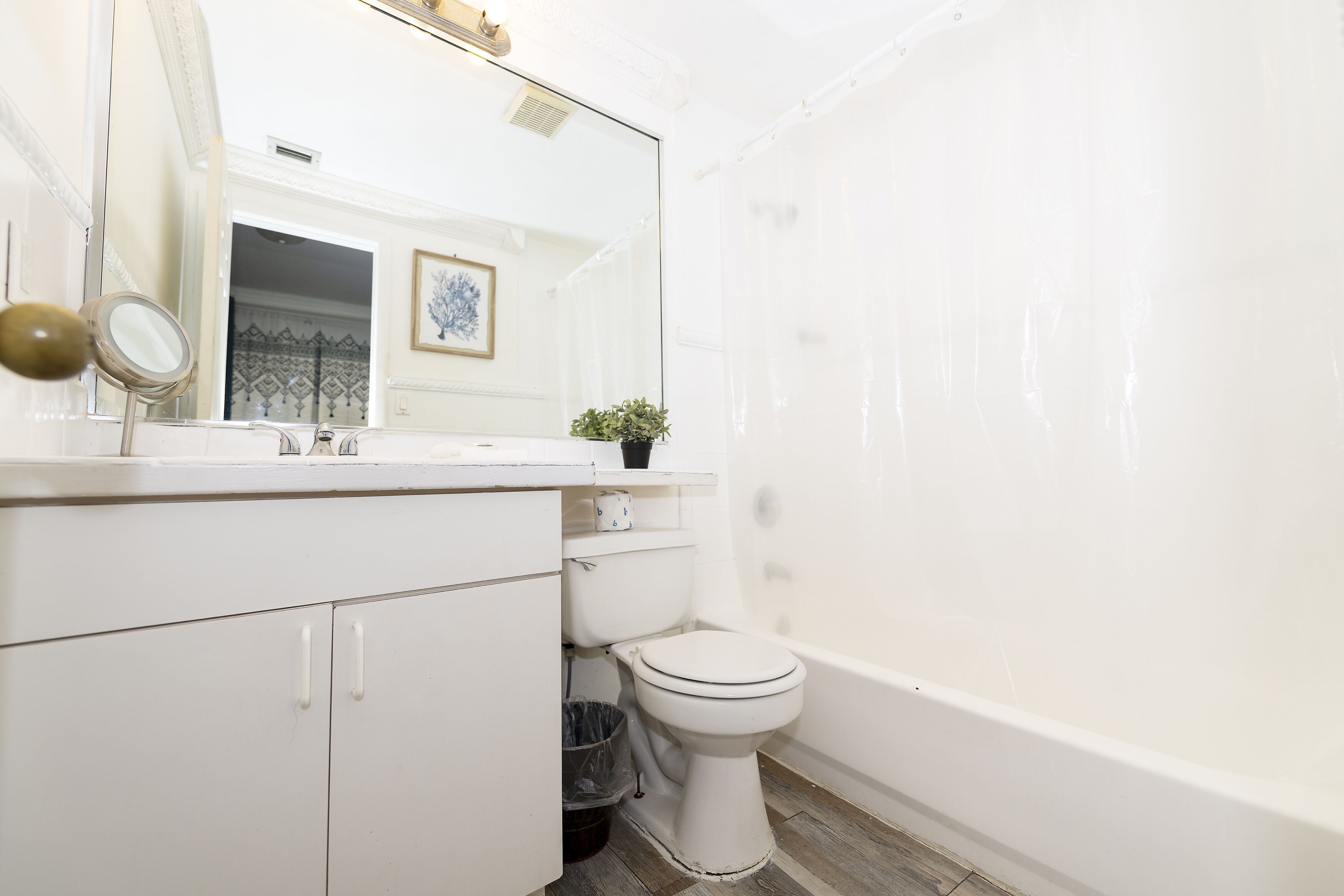 Une salle de bain comprenant des toilettes, un lavabo, un miroir et une baignoire.