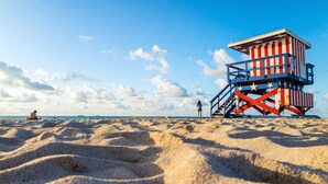 A lifeguard tower on a sandy beach with a clear sky. - OCEAN DRIVE APARTMENTS (Miami Beach)