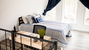 A bedroom with a bed, a desk, and a window with curtains. - Ridge Point | Walk to Glen Arbor | Pet-Friendly | Close to Sleeping Bear Dunes (Glen Arbor)