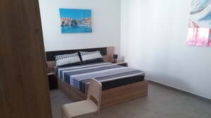 Een slaapkamer met een bed, nachtkastjes, een stoel en een schilderij aan de muur.
