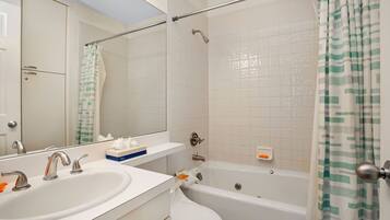 Een bad/douchecombinatie, een haardroger, handdoeken, shampoo