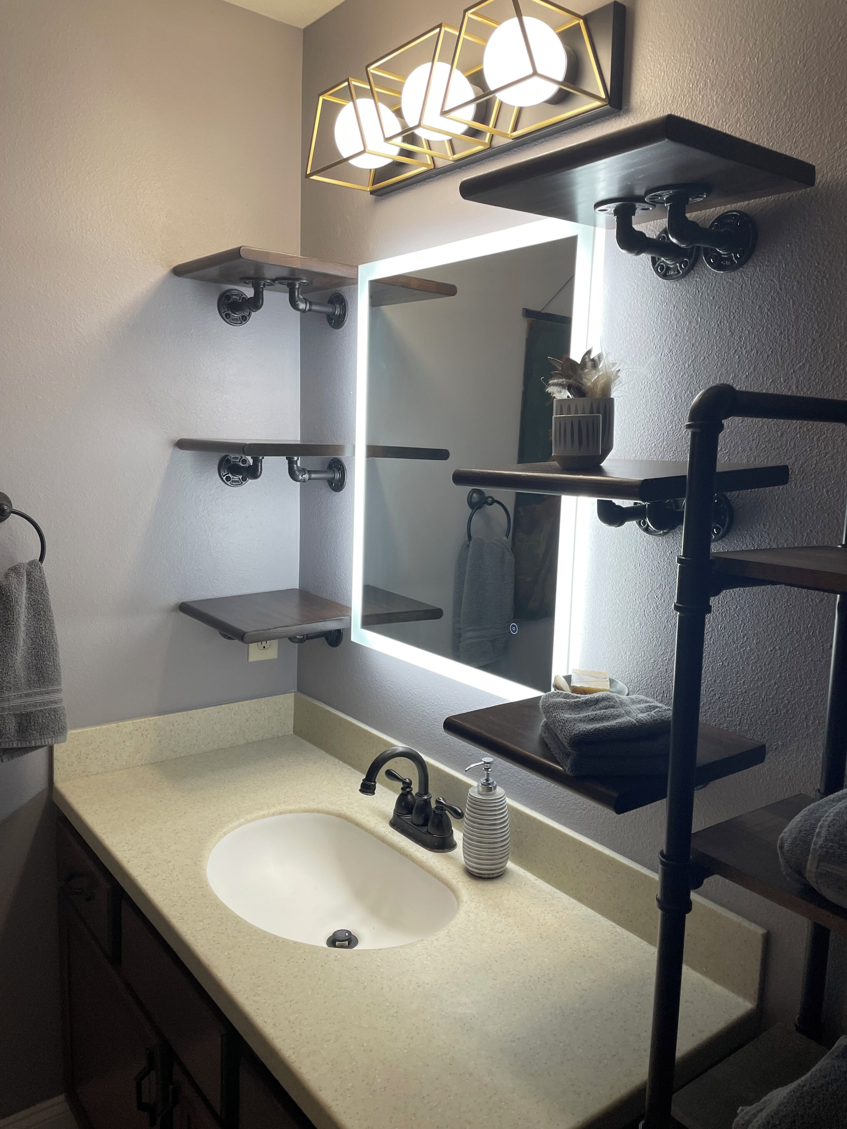 Une salle de bain avec un lavabo blanc, un miroir et des porte-serviettes.