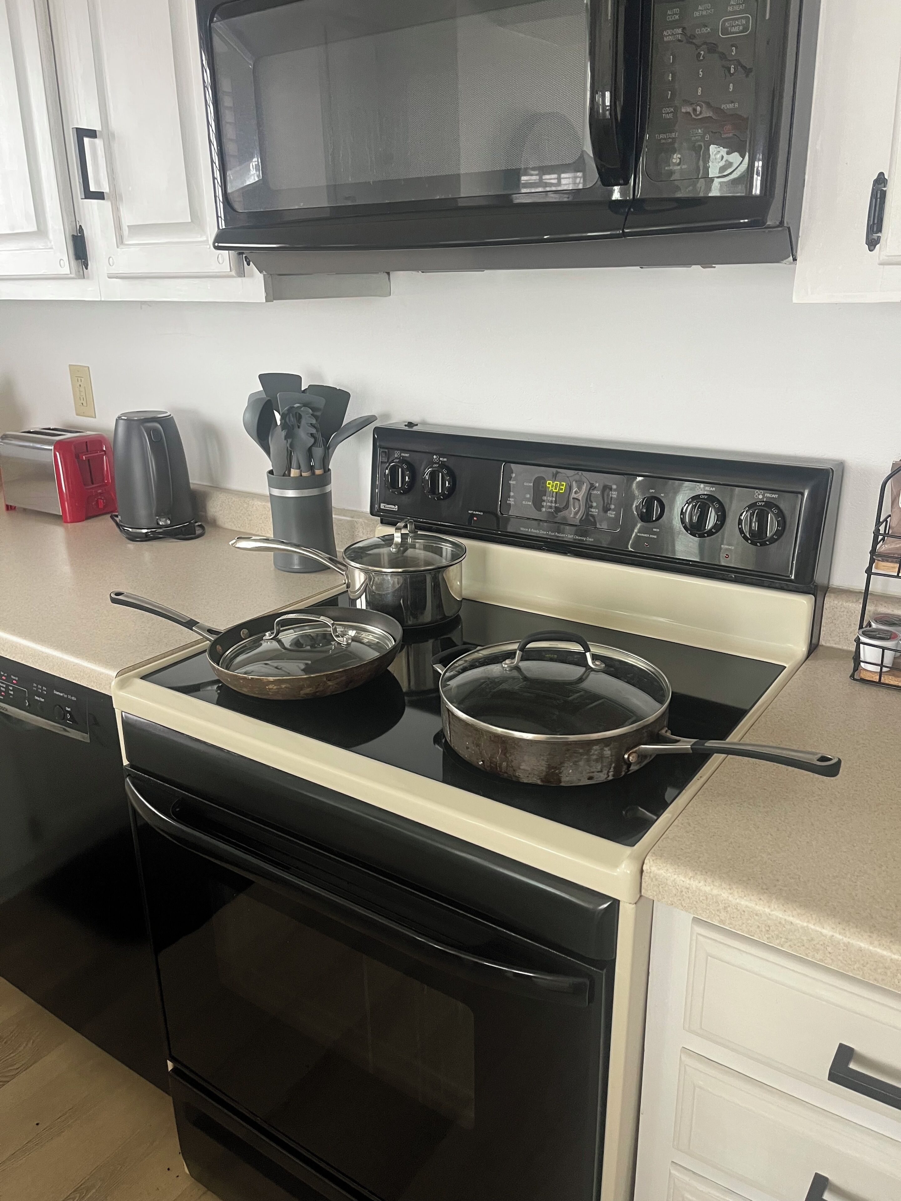 A kitchen with a stove, microwave, toaster, and coffee maker.