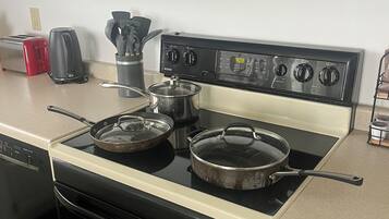 A kitchen with a stove, microwave, toaster, and coffee maker.