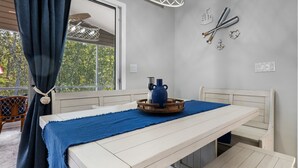 A room with a white table, blue throw, and a kettle on a tray.