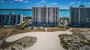 A high-rise hotel with multiple floors, a central courtyard, and a beach view.