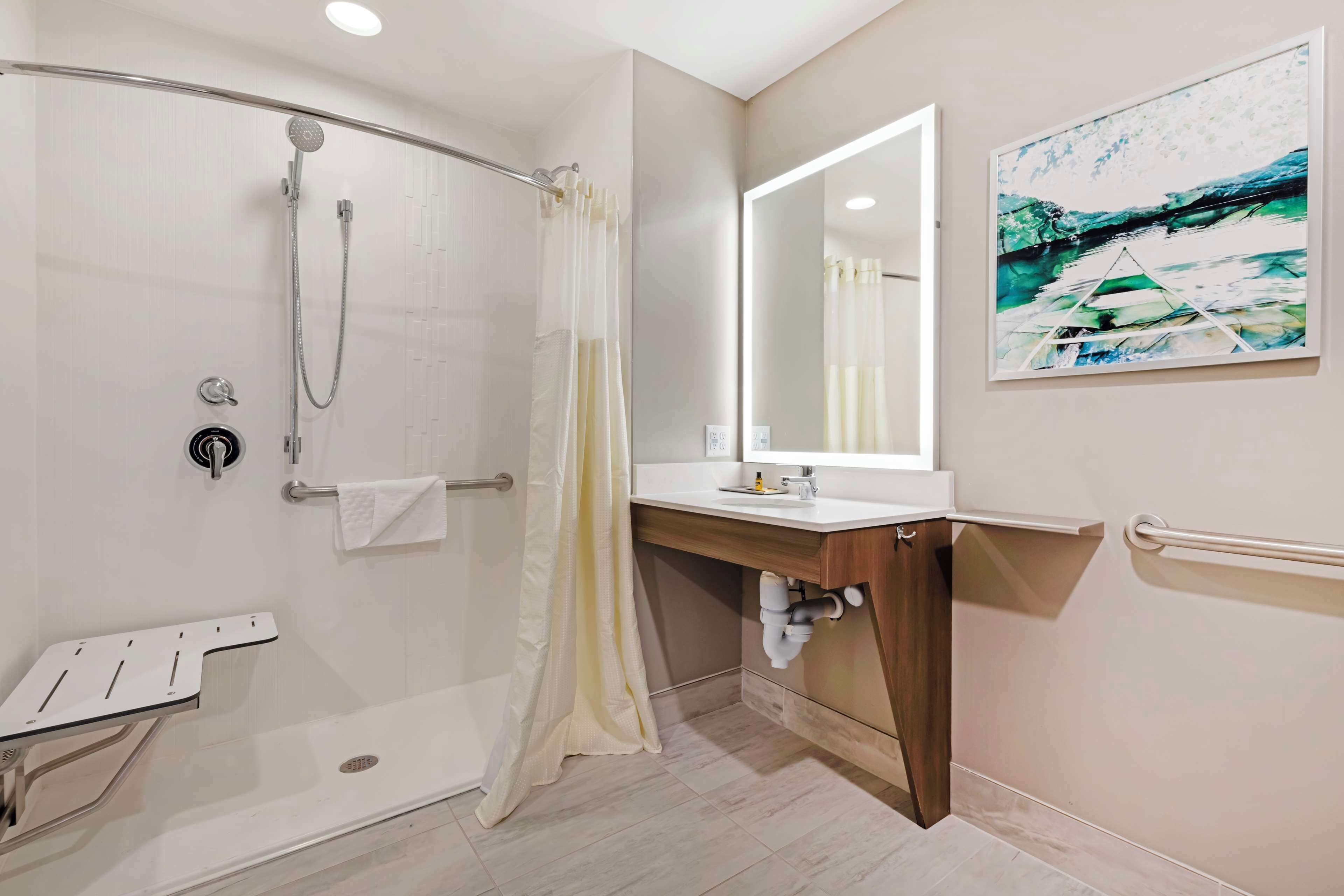 A modern bathroom with a walk-in shower, a vanity with a mirror, and a toilet.