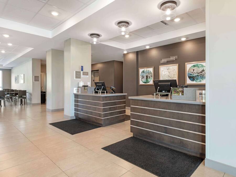A reception area with two reception desks, a seating area with chairs, and artwork on the walls.
