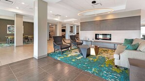 A modern hotel lobby with a seating area, a fireplace, and a large abstract painting on the wall. - Best Western Plus Grand Rapids MN (Grand Rapids)