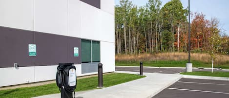 A modern building with a parking lot and electric vehicle charging station.