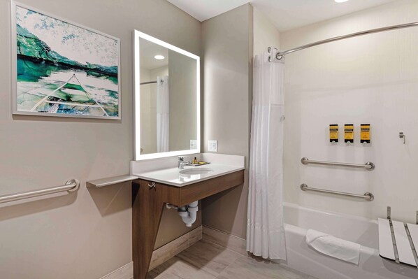 A modern bathroom with a sink, mirror, shower, and handrails. - Best Western Plus Grand Rapids MN (Grand Rapids)
