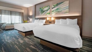 A hotel room with two beds, a desk, and a large window with curtains. - Best Western Plus Grand Rapids MN (Grand Rapids)