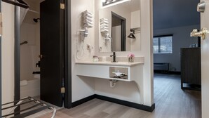 A modern bathroom with a vanity, towel rack, and a mirror. - The Scout INN (Cody)