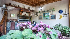 A rustic kitchen with wooden beams, a stone countertop, and a wooden table. - Bali Dorian Apartments (Mylopotamos)