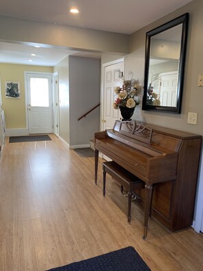 Enter a refined space with a grand piano and elegant decor.