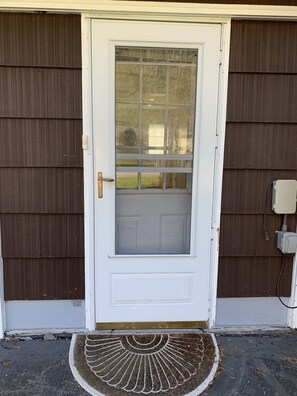 Welcome to a charming entrance with a glass door panel and a sun-inspired doormat.