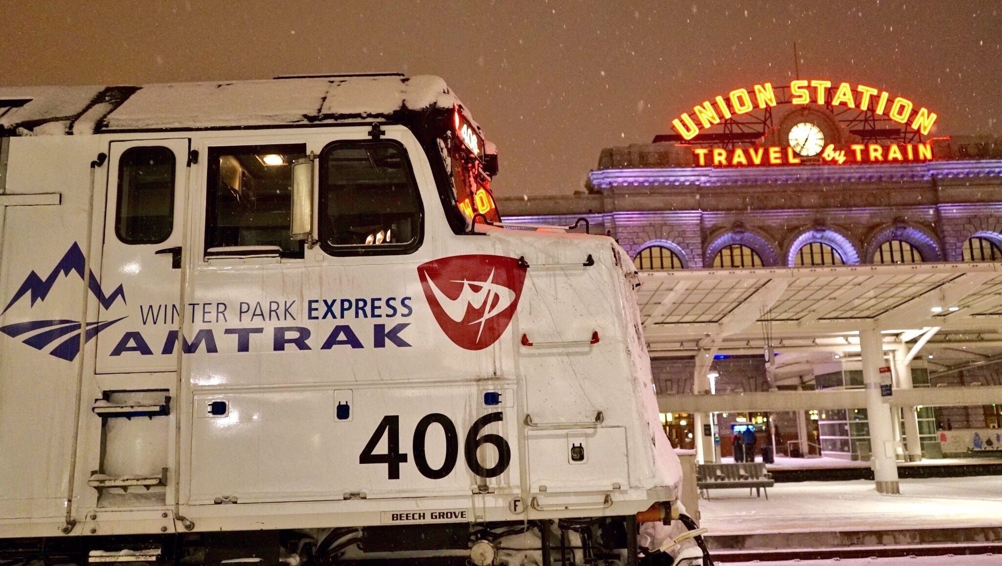Ein Zug mit 'Winter Park Express' und 'AMTRAK'-Beschriftung, Nummer 406, an einem Bahnhof mit einem 'Union Station'-Schild.