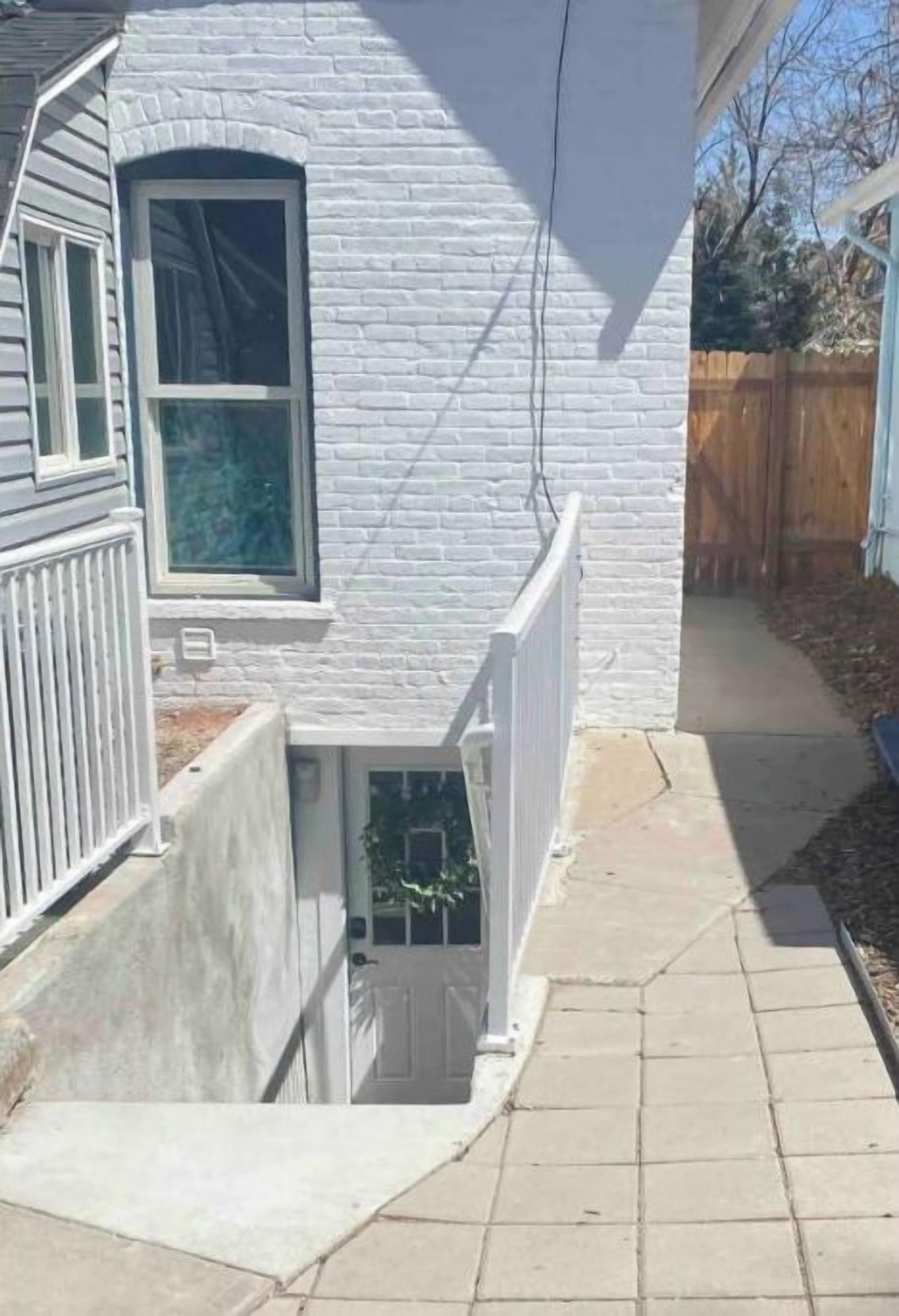 A house with a white exterior, a small front porch, and a visible door.