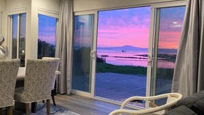 Een moderne woonkamer met een grote schuifdeur die leidt naar een balkon met een prachtig uitzicht.