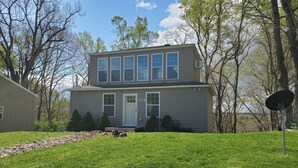 A two-story house with a front door, a garage, and a satellite dish.