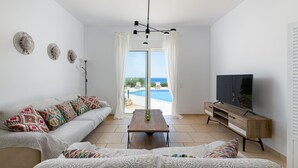 Una sala moderna con un sofá, una mesa de centro y un mueble para televisión.