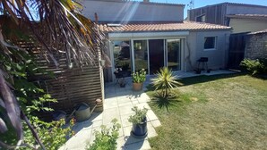 A house with a tiled roof, a patio with potted plants, and a lawn. - House (AYTRE)