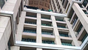 A multi-story building with a modern architectural design, featuring a central atrium with a glass ceiling and multiple balconies.