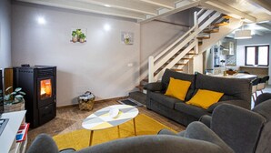 A modern living room with a sofa, armchairs, a coffee table, a fireplace, and a staircase. - Country house in Llanes for trips with family or friends  (Soberron, Llanes)