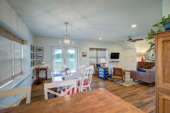 A spacious living area with a dining table, chairs, a sofa, and a television. - Cozy, secluded country home on acreage and pond! **Wild Blue Yonder** (Greenville)