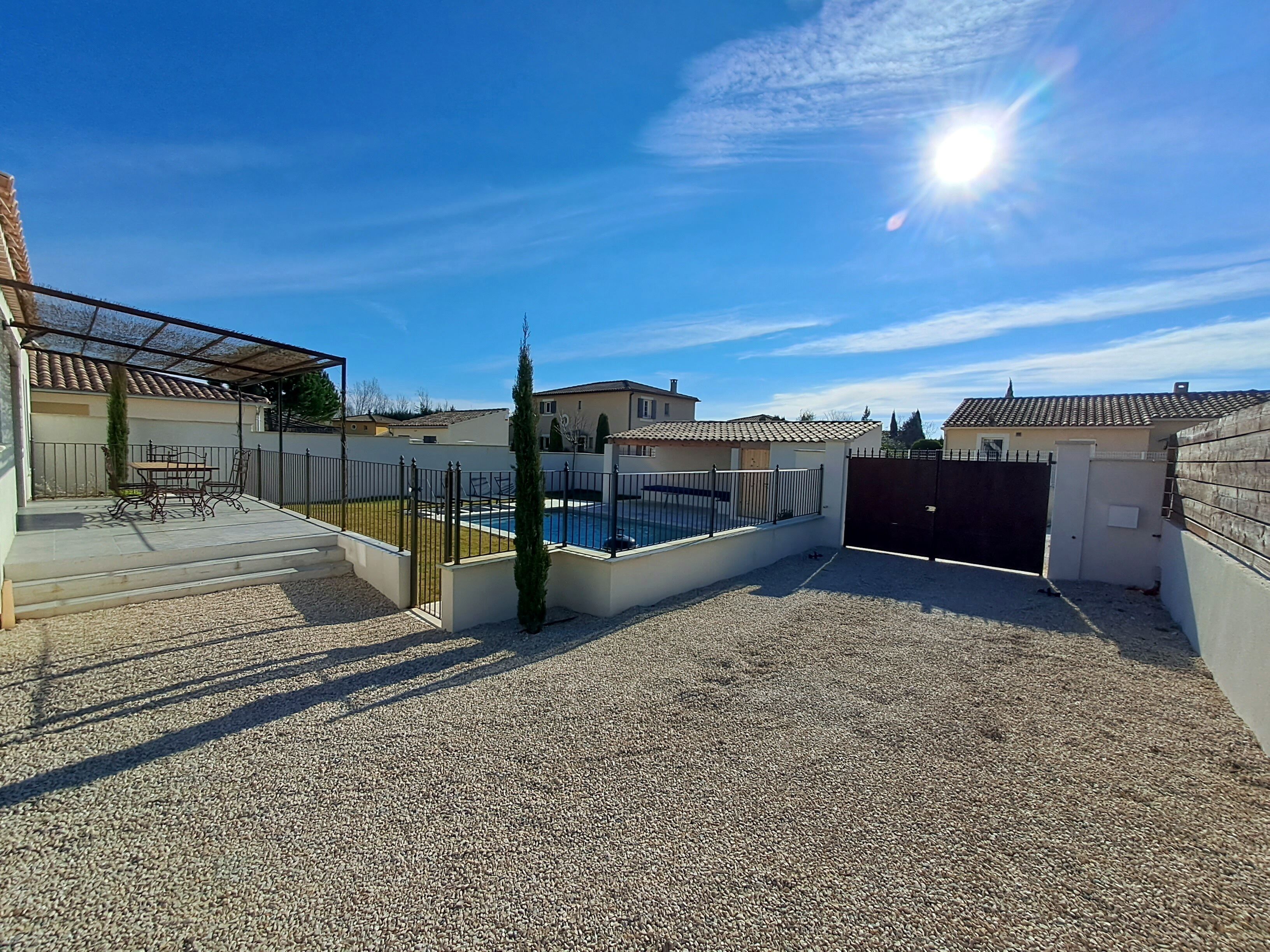 Un quartier résidentiel doté d’une piscine, d’un patio couvert et d’une allée gravillonnée.