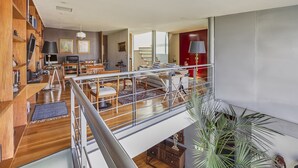 A spacious living area with a high ceiling, wooden shelving, a dining area, and a balcony with a railing. - Amazing PH w/great terrace in the heart of Condesa (Mexico)