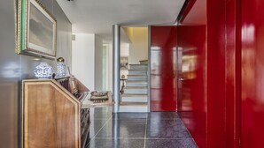 A hallway with a wooden cabinet, a framed picture, and a red door. - Amazing PH w/great terrace in the heart of Condesa (Mexico)