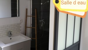 A bathroom with a white sink, mirror, and a shower area with a glass door. - 1 Bedroom Apartment in Aubenas (Aubenas)